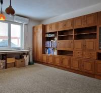 A családi házban van egy dolgozószoba fa polcos fallal, nagy asztallal és szőnyegpadlóval.