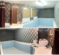 Családi ház belső tere medencével és zuhanyzóval, téglalap alakú csempékből és mozaikból.