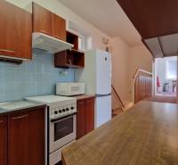 Konyha családi házban fa dekorral, kék csempékkel és konyhabútorral.