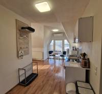 Családi ház belső tere konyhával és étkező sarokkal, fa dekorációjú padlóval.