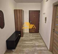 Hangulatos előszoba egy háromszobás lakásban, fa dekor padlóval és szekrénnyel.