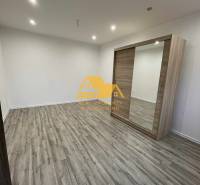 1 szobás lakás belső tere fa dekor padlóval és beépített szekrénnyel.