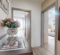 Folyosó egy 3 szobás lakásban virágos dekorációval és fa padlóburkolattal.