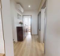 Folyosó egy 3 szobás lakásban fa dekor padlóval, komóddal és légkondicionálóval.