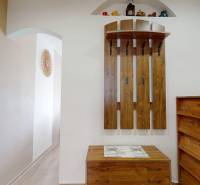 Előszoba egy háromszobás lakásban fa dekorral és fogasfallal.