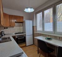 Konyha egy 2 szobás lakásban, fa dekoros padlóval és háztartási gépekkel.