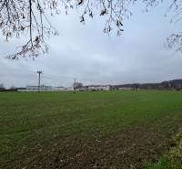 Zöldterületek és épületek Pruskéban, kereskedelmi telkek a háttérben elterülve.