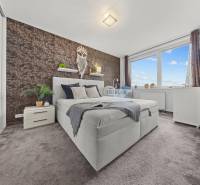 Hálószoba egy kétszobás lakásban franciaággyal, szőnyegpadlóval és dekoratív fallal.