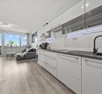 Konyha és nappali egy kétszobás lakásban fa dekoros padlóval.