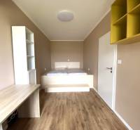 Szoba egy háromszobás lakásban fa dekor padlóval és beépített asztallal.