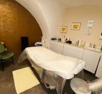 Masszázsasztal boltíves mennyezetű üzlethelyiségben, amelyhez tartozékok is tartoznak.