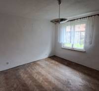 Üres szoba ablakkal, csillárral és fa dekorációjú padlóval egy családi házban.