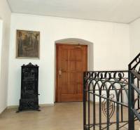 Iroda folyosója festménnyel, faajtókkal és cserépkályhával.