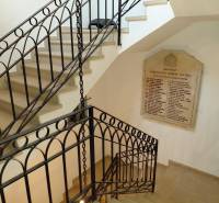 Irodai belső tér csigalépcsővel és táblával a falon, fa dekorációjú padlóval.