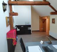 Gerendás mennyezetű és fa dekorációjú padlójú irodák, polcok takaróval, asztal dokumentumokkal.