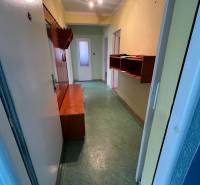 Folyosó egy 3 szobás lakásban beépített bútorokkal és zöld padlóval.