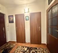 Előszoba egy kétszobás lakásban, fa dekorációjú padlóval és három ajtóval.