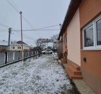 Családi ház az Új utcában, Nagy Ozorócban, havas udvarral és kerítéssel.