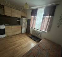 Konyhaszekrény fa dekorációval az egyszobás lakásban, része a tűzhely és a hűtőszekrény.