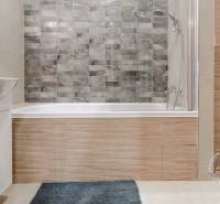 Fürdőszoba egy kétszobás lakásban káddal, mosdóval és WC-vel, csempézett burkolattal.