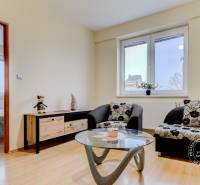 Nappali egy kétszobás lakásban kanapéval és dekorációs elemmel ellátott asztallal.