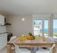 Tengerre néző nyaraló apartman, étkezőasztal és konyhapult.