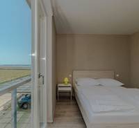 Hálószoba rekreációs apartmanban kilátással, ággyal és fa dekorációjú padlóval.