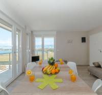 Étkezőasztal a tengerre néző nyaraló apartmanban nagy ablakokon keresztül.