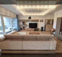 Nappali egy üdülő apartmanban kényelmes ülőgarnitúrával és dekoratív világítással.