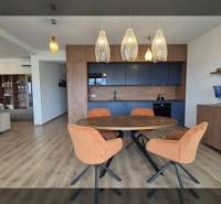 Nyaraló apartman belső tere fa mintázatú padlóval és étkezőasztallal.