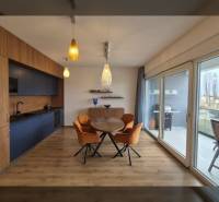 Étkező sarok fa dekorációjú padlóval és nagy ablakokkal egy üdülő apartmanban.