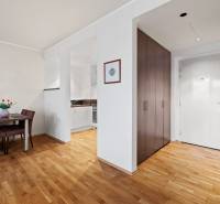 2 szobás lakás belső tere étkezővel, konyhával és bejárattal, fa mintázatú padlóval.