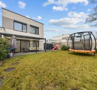 A Topoľová utcai, Rovinkában található 4 szobás lakás kertje trambulinnal és terasszal.