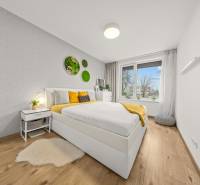 Hálószoba ággyal és faldekorációkkal, fa dekorációs padlóval.