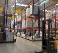 A raktárakban és csarnokokban magas polcokat látunk raklapokkal és targoncával.