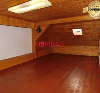 Tetőtéri helyiség fa dekorációval üzlethelyiségben, kis tetőablakkal.