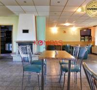 Üzlethelyiség stílusos székekkel, asztallal és kandallóval, rendezvényekre alkalmas.