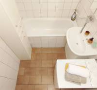 Kétszobás lakás fürdőszobája káddal, mosdóval és mosógéppel.