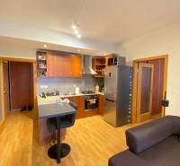 Konyha egy kétszobás lakásban fa dekor padlóval és bárpulttal.