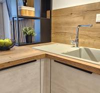 Konyhapult az egyszobás lakásban mosogatóval és fa dekoros padlóval.