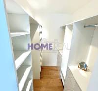 Gardrób egy háromszobás lakásban tárolóhelyekkel és fa dekorációjú padlóval.