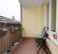 A Jégeho 8-ban, Pozsony-Ružinovban található kétszobás lakás erkélye virágládákkal és székekkel.