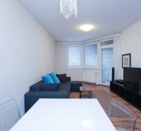 Nappali egy kétszobás lakásban kanapéval, televízióval és fa dekorációjú padlóval.