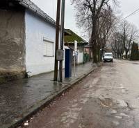 Családi ház a Komenského utcában, Surányban, az út mellett villanyoszloppal és fákkal.