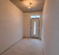 Folyosó egy családi házban egyszerű világítással és műanyag ajtókkal.