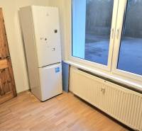 Konyhasarok a 3 szobás lakásban, fa dekorációjú padlóval és háztartási géppel.