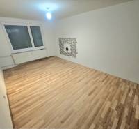 Nappali szoba fa dekor padlóval és ablakkal egy háromszobás lakásban.