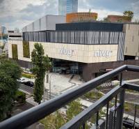 Kilátás az erkélyről a pozsonyi Nivy bevásárlóközpontra modern építészettel.