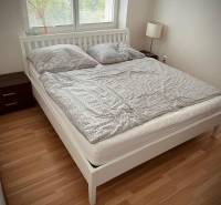 Hálószoba egy kétszobás lakásban fa dekor padlóval és franciaággyal.