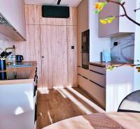 Konyha egy háromszobás lakásban fa dekorációval és beépített készülékekkel.